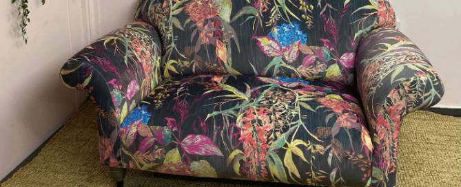 2 seater sofa upholstered in a vibrant fabric on a hessian rug