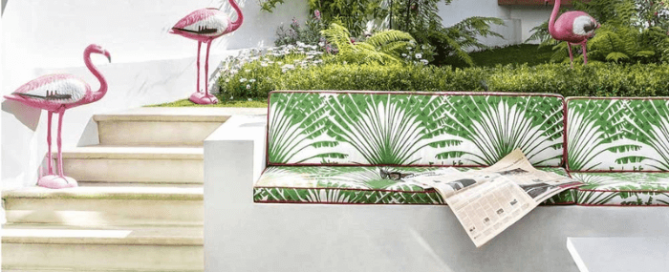 Garden seat with cushions in a green palm tree design Palma Verde by Michael Szell. Flamingos in the background