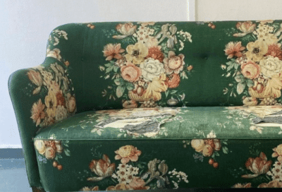 Green sofa needing upholstery in a vintage floral design
