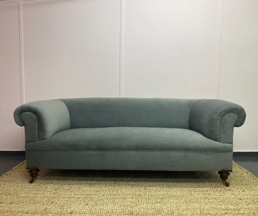 Grey sofa with castors and scroll sshaped arms